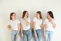 Beautiful young ladies in jeans and white t-shirts on background. Woman`s Day Royalty Free Stock Photo