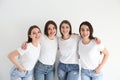 Beautiful young ladies in jeans and white t-shirts on background. Woman`s Day Royalty Free Stock Photo