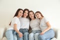 Beautiful young ladies in jeans and white t-shirts on sofa. Woman`s Day Royalty Free Stock Photo