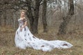 Beautiful young lady in gorgeous vintage white dress. Snow.