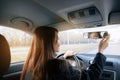 Beautiful young lady looking back through the rear view mirror of a car while reversing. Royalty Free Stock Photo