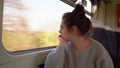 Beautiful, young lady travels by train, looks out the window and resent