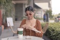 A beautiful young lady wearing a frameless sunglasses attempts to open the straw for her drink