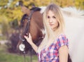 Beautiful young lady wearing t-shirt and jeans riding a horse at