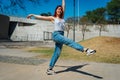 Beautiful young latina dancing happily in the street while partying with jumps and somersaults. Concept of joy, street dance, hip