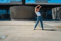 Beautiful young latina dancing happily in the street while partying with jumps and somersaults. Concept of joy, street dance, hip