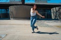 Beautiful young latina dancing happily in the street while partying with jumps and somersaults. Concept of joy, street dance, hip