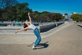 Beautiful young latina dancing happily in the street while partying with jumps and somersaults. Concept of joy, street dance, hip