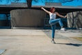 Beautiful young latina dancing happily in the street while partying with jumps and somersaults. Concept of joy, street dance, hip