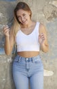 Stunning young Latina woman poses in white tank top and denim - desert