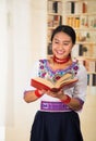 Beautiful young lawyer wearing black skirt, traditional andean blouse with necklace, standing posing for camera, holding Royalty Free Stock Photo