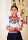 Beautiful young lawyer wearing black skirt, traditional andean blouse with necklace, standing posing for camera, serious Royalty Free Stock Photo