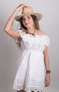 Beautiful young leggy blond Country girl in a litl white dress and cowboy hat with a guitar Royalty Free Stock Photo