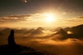 Beautiful young long hair girl tourist enjoy daybreak on the sharp corner of sandstone rock and watch over valley to Sun.