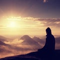 Beautiful young long hair girl tourist enjoy daybreak on the sharp corner of sandstone rock and watch over valley to Sun. Royalty Free Stock Photo