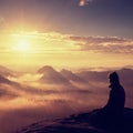 Beautiful young long hair girl tourist enjoy daybreak on the sharp corner of sandstone rock and watch over valley to Sun. Royalty Free Stock Photo