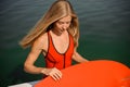 Beautiful long-haired blonde woman holding a wake board