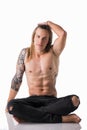 Beautiful young long haired man shirtless, sitting on the floor