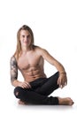 Beautiful young long haired man shirtless, sitting on the floor Royalty Free Stock Photo