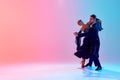 Beautiful young man and handsome woman, ballroom dancers making performance, dancing against gradient pink blue Royalty Free Stock Photo