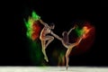 Beautiful young man and woman, talented ballet dancers in beige bodysuits dancing with colorful powder explosion against