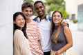 Beautiful young men and women smiling and looking at camera.Diverse group of joyful millennial people staring happy at Royalty Free Stock Photo