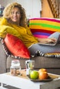 Beautiful young middle age woman enjoy home and work with laptop computer on the sofa in morning breakfast time - concept of happy Royalty Free Stock Photo