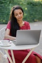 beautiful and young millennial african woman in a public place working on a laptop