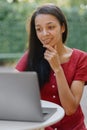 beautiful and young millennial african woman in a public place working on a laptop