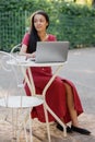 beautiful and young millennial african woman in a public place working on a laptop