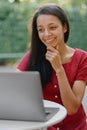 beautiful and young millennial african woman in a public place working on a laptop