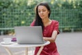 beautiful and young millennial african woman in a public place working on a laptop