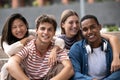 Beautiful young millennials smiling looking at camera.Group of friends sitting together happy and carefree in the street Royalty Free Stock Photo