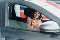 Beautiful young mixed race black African American woman driving car and show holding the key Royalty Free Stock Photo