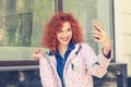 Woman taking a selfie with smart phone outdoors smiling Royalty Free Stock Photo