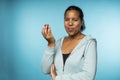 Beautiful young mixed race woman in casual clothing eating and enjoying a fresh strawberry with a blue background Royalty Free Stock Photo