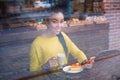 Beautiful young mixed race woman seen through the window of bakery Royalty Free Stock Photo