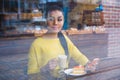 Beautiful young mixed race woman seen through the window of bakery Royalty Free Stock Photo