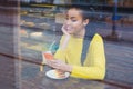 Beautiful young mixed race woman seen through the window of bakery Royalty Free Stock Photo