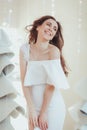 Beautiful young model smiling and posing at the photo studio, fashion fabric christmas tree on background.