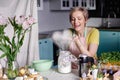 Modern housewife cooks in the kitchen. portrait of a woman cook with mixer. Preparing for Easter Royalty Free Stock Photo