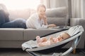 Beautiful young mother with baby girl working at home office using laptop computer, sun light. Concept freelance life Royalty Free Stock Photo