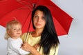 A young mother with a baby under the red umbrella Royalty Free Stock Photo