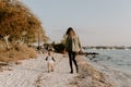 Beautiful Young Mother and Cute Little Boy Son Walking and Enjoying the Nice Outdoor Weather on the Sandy Beach next to the Ocean Royalty Free Stock Photo