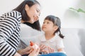 Beautiful young mother doing manicure to her cute smiling daughter applying nail polish Royalty Free Stock Photo