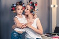 Beautiful young mother and her daughter with hair curlers Royalty Free Stock Photo