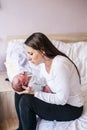 Beautiful young mother with her newborn baby son, bedroom Royalty Free Stock Photo