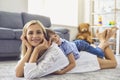 Beautiful young mother and her son lying on soft carpet at home. Cute boy hugging his mom on floor in living room Royalty Free Stock Photo