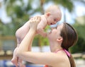 Beautiful young mother is holding baby girl outside near pool. Royalty Free Stock Photo