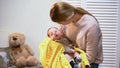 Beautiful young mother holding little baby son in arms, newborn love and care